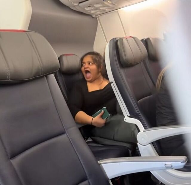 A passenger reacts as cabin crew address the noise disruption.