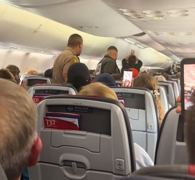 Fellow passengers cheer as the disruptive individual is removed.