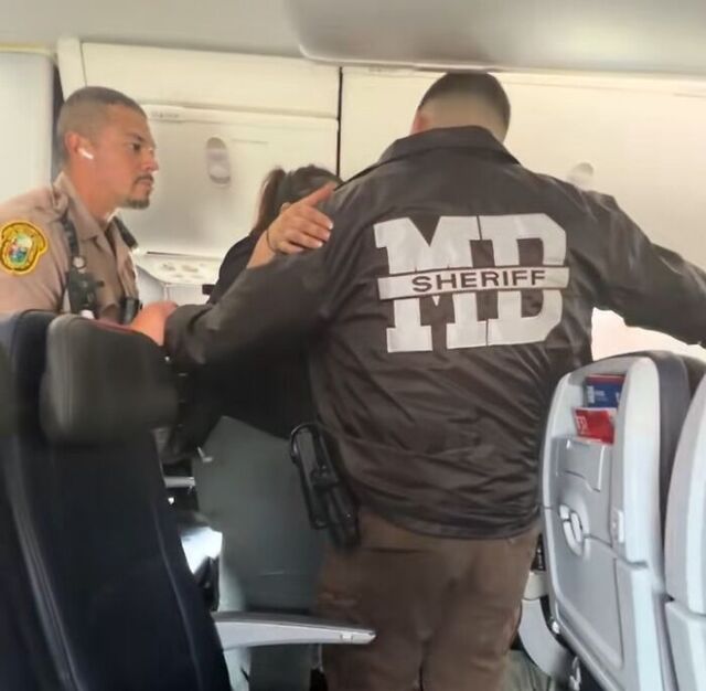 Law enforcement prepares to escort the woman off the flight.